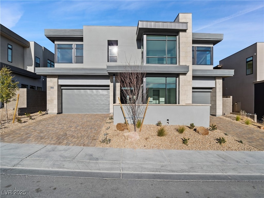 Modern home with a garage, decorative driveway, an