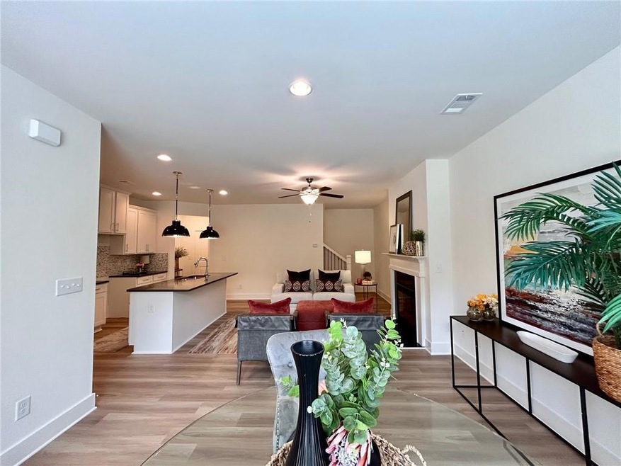 Living room with ceiling fan, recessed lighting, a fireplace, light wood-type flooring, and baseboards