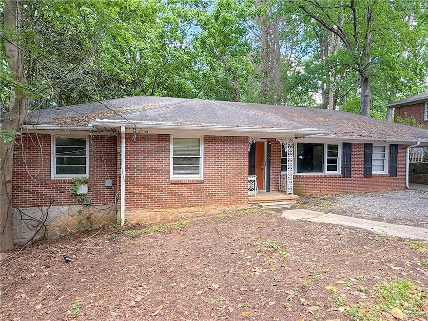 Ranch-style home with a shingled roof, brick sidin