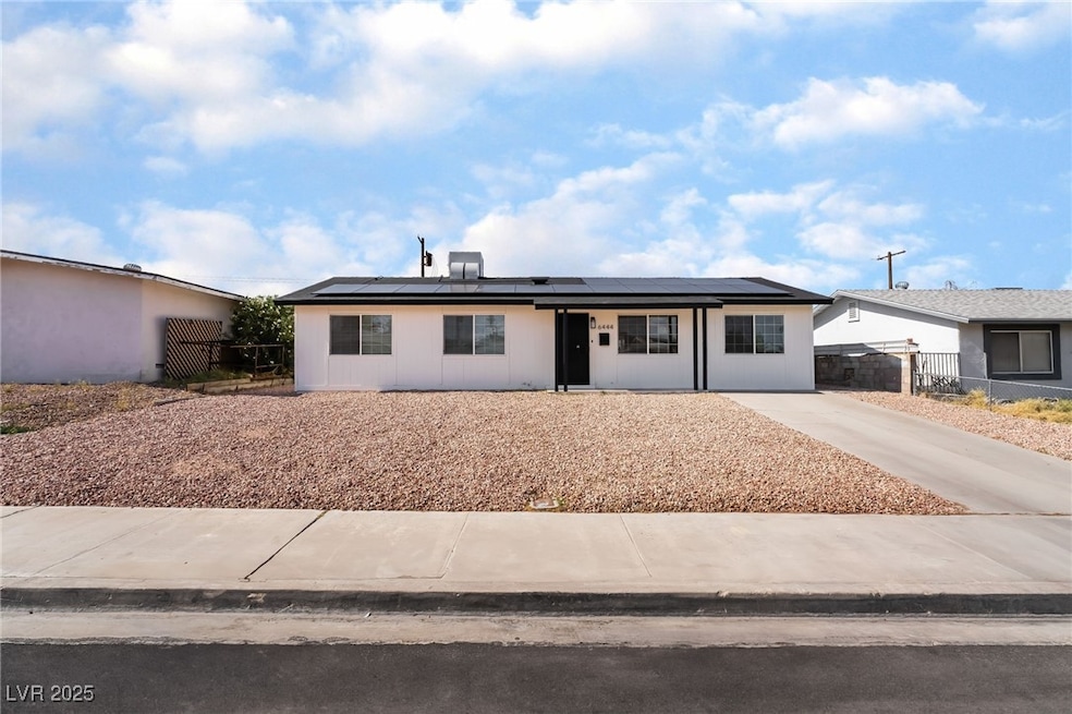 Ranch-style house featuring solar panels and driveway