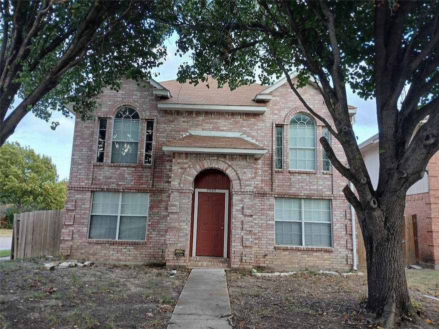 View of front facade with brick siding and a shingled roof