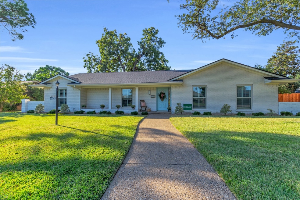 Ranch-style home with covered porch, brick siding, and roof with shingles
