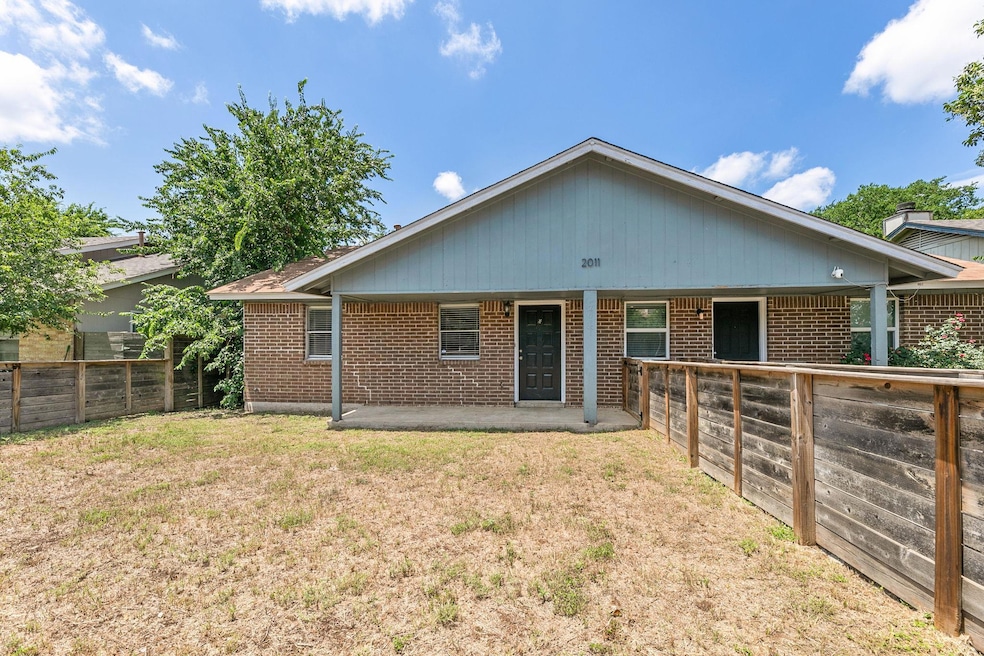 Rear view of property with a patio area and brick