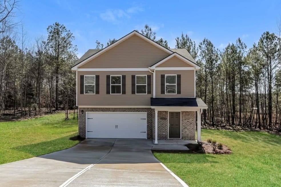 View of front property featuring a garage and a front lawn