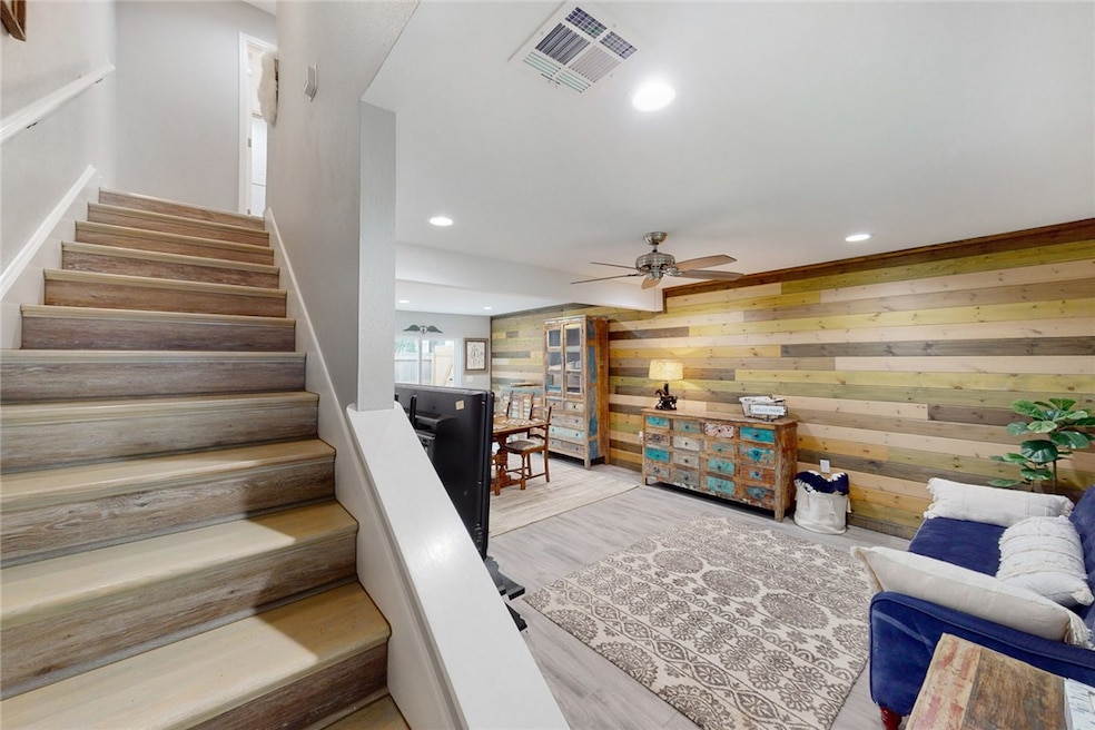 Stairs with wood finished tile floors, recessed li