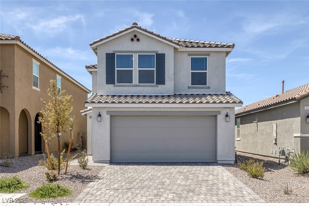 View of front of home with a tiled roof, an attach