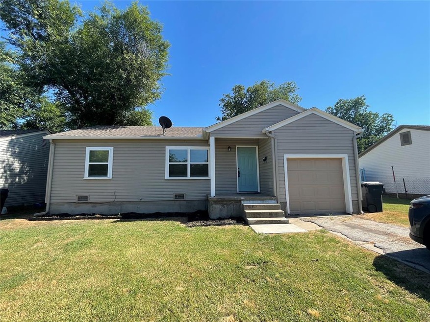 View of front of home featuring a front lawn and a garage