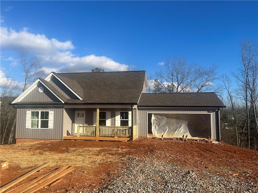View of front of property with a garage and a porc