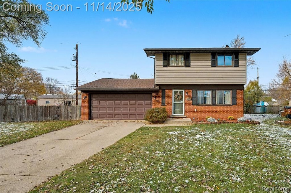 Colonial-style house featuring brick siding, concrete driveway, and an attached garage