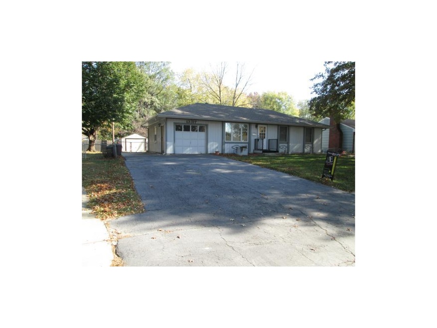 Front view of home with large driveway and metal s