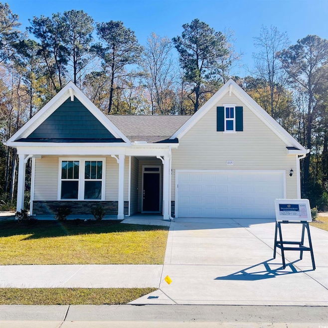 View of front facade with a porch, concrete driveway, a front yard, and stone siding