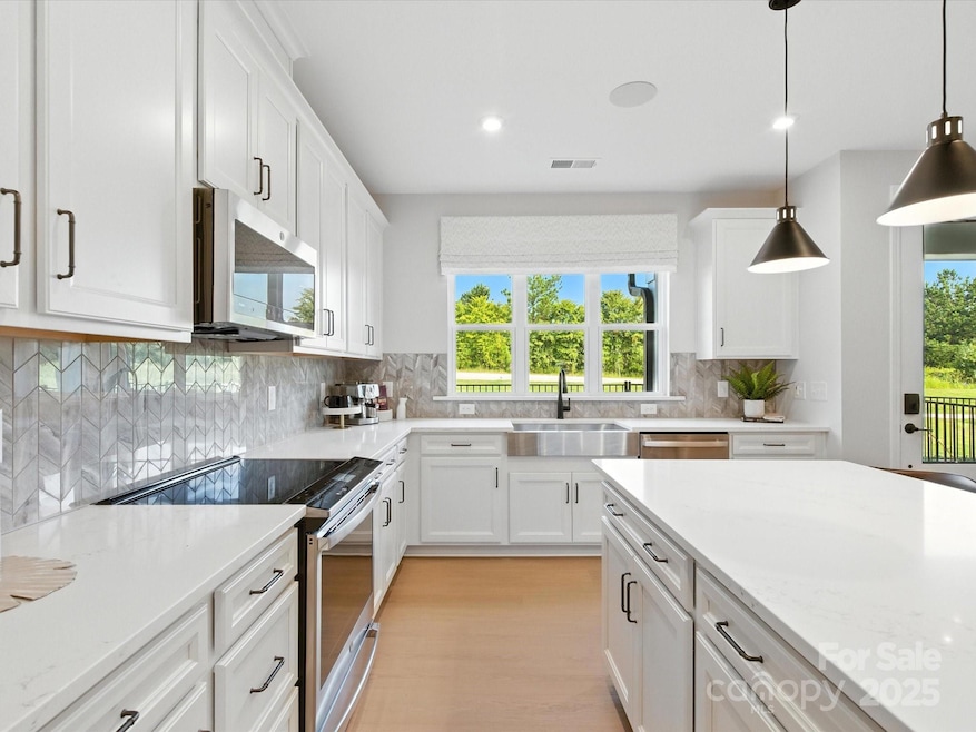 Chef's Kitchen Layout and Sleek GE Stainless Appliances. *Model Photos | Actual Finishes, Structural Selections, and Orientation May Vary.