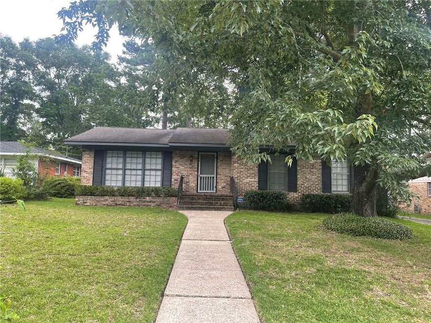 View of front of property featuring a front yard and brick siding