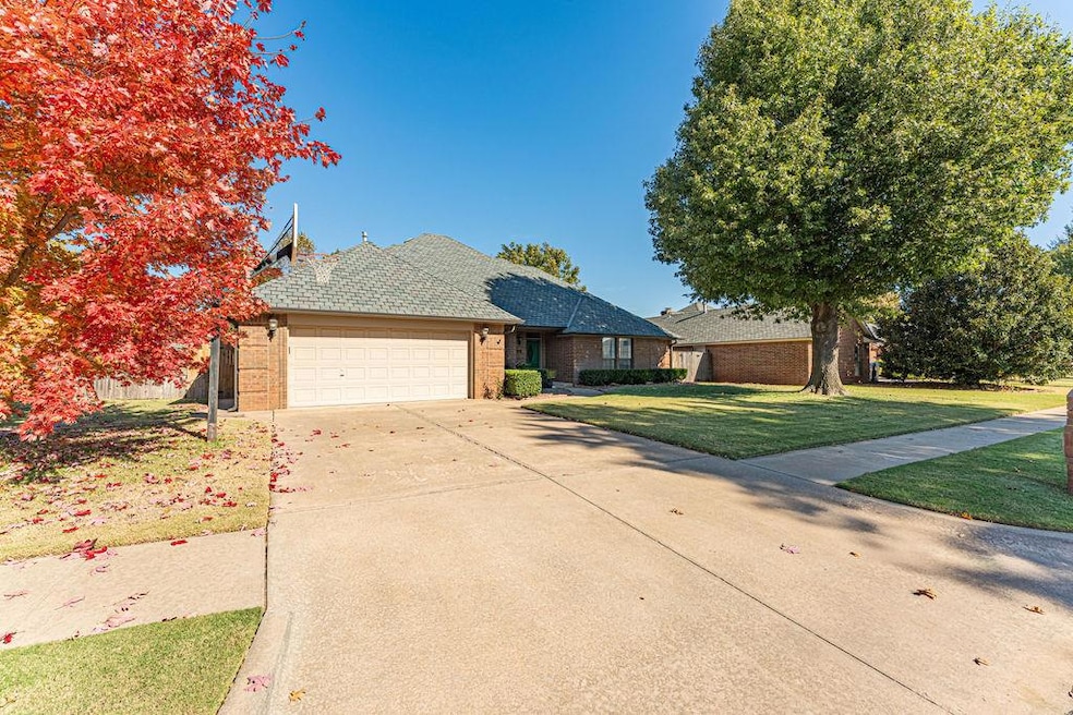 View of front of house with brick siding, driveway, a front lawn, a shingled roof, and a garage