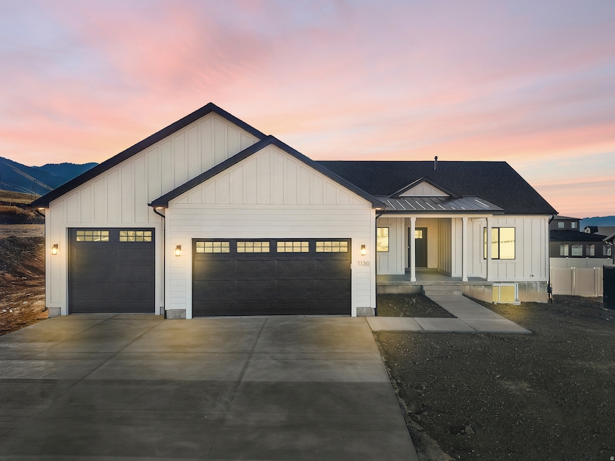 Modern farmhouse featuring board and batten siding, a garage, and driveway