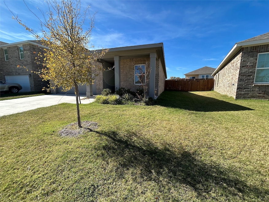 View of front facade featuring driveway and brick siding