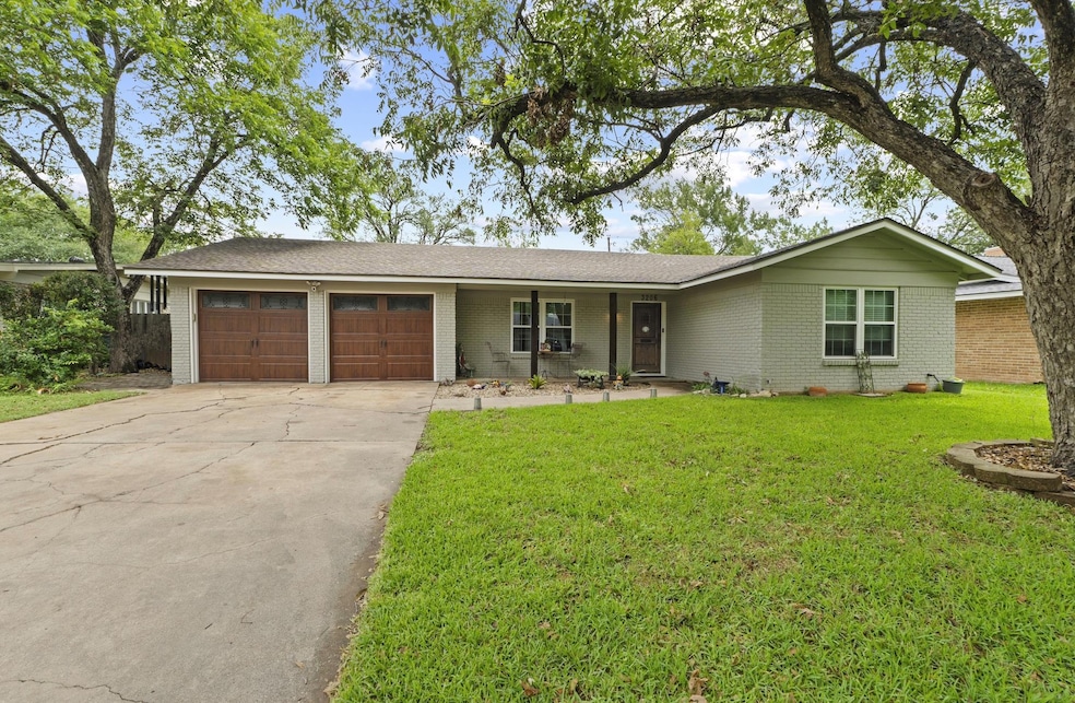 Ranch-style home featuring a garage, brick siding, concrete driveway, and a front yard
