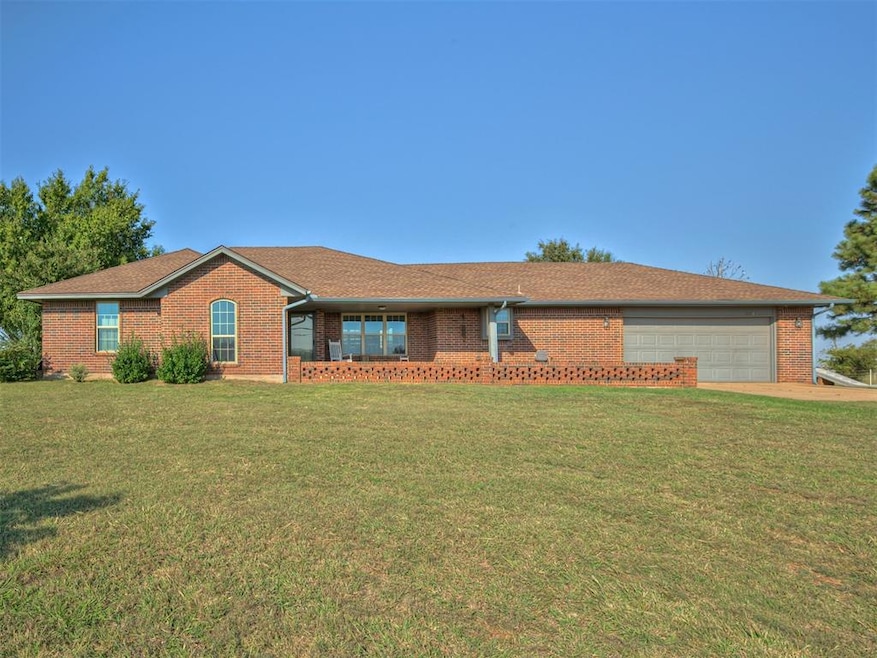 Single story home featuring a front lawn, brick siding, roof with shingles, and a garage
