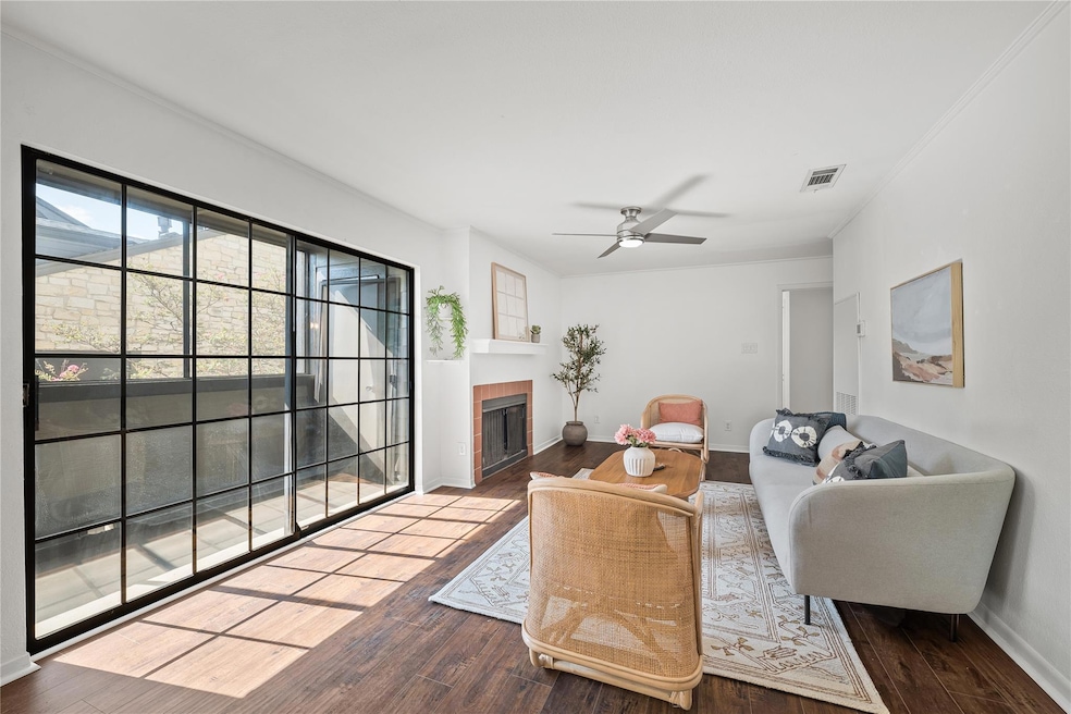 Living room with a fireplace, dark wood-style flo