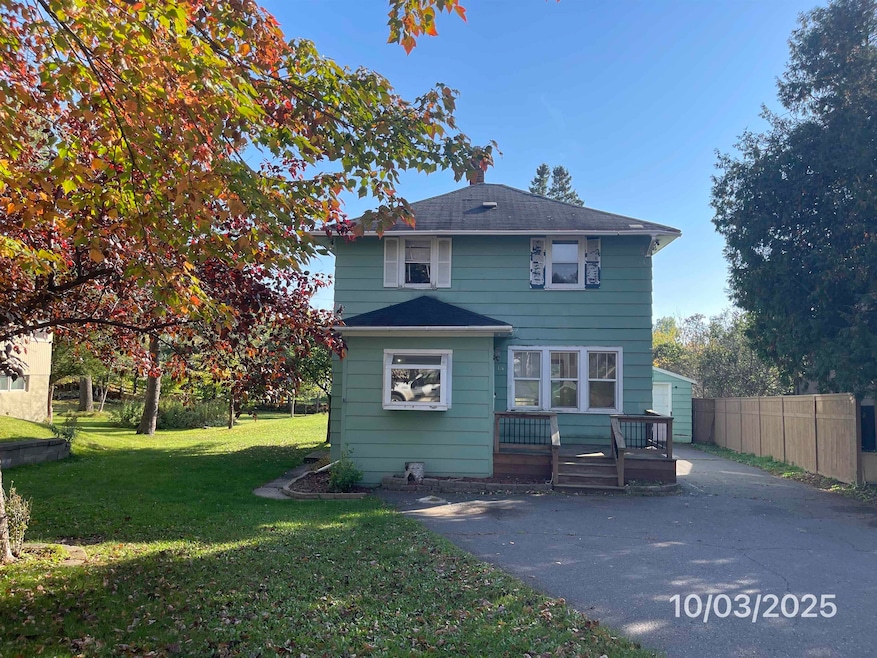 View of front of property with a wooden deck and a front yard