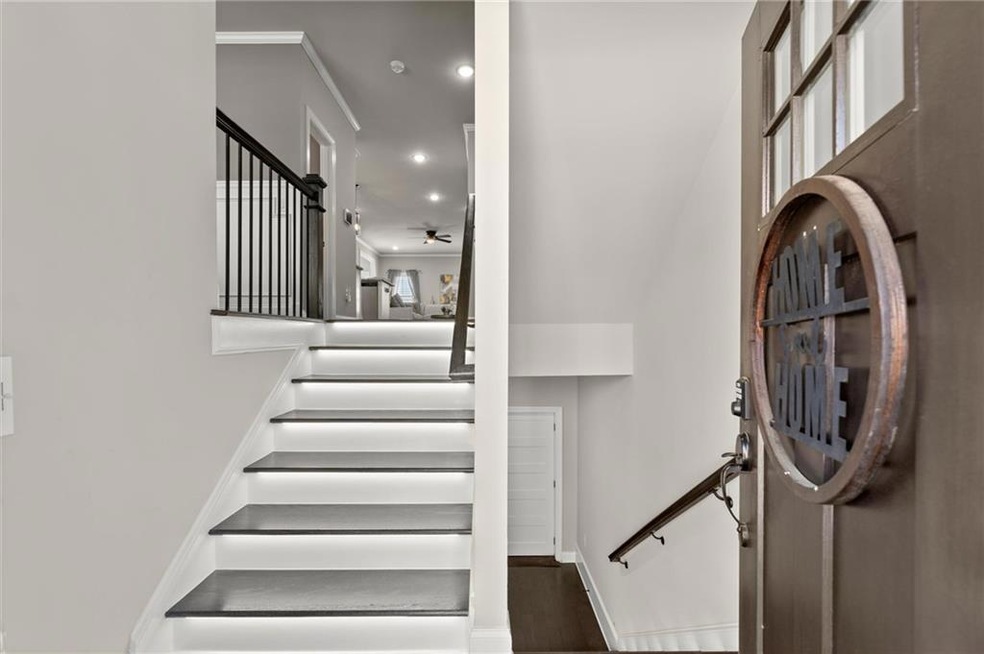 Staircase with recessed lighting, wood finished floors, a ceiling fan, and crown molding
