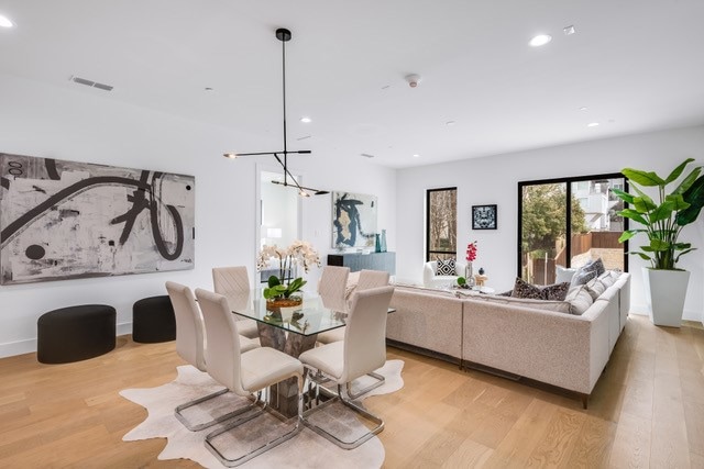Dining space with an inviting chandelier, light wood-style flooring, visible vents, and recessed lighting