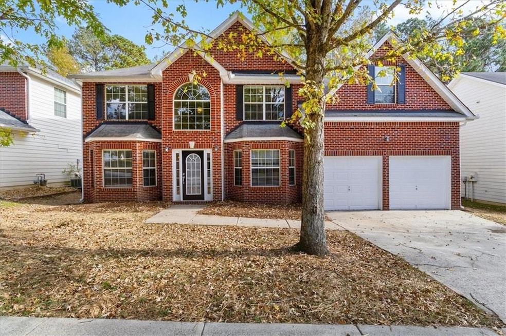 View of front of house with brick siding, concrete driveway, and a garage