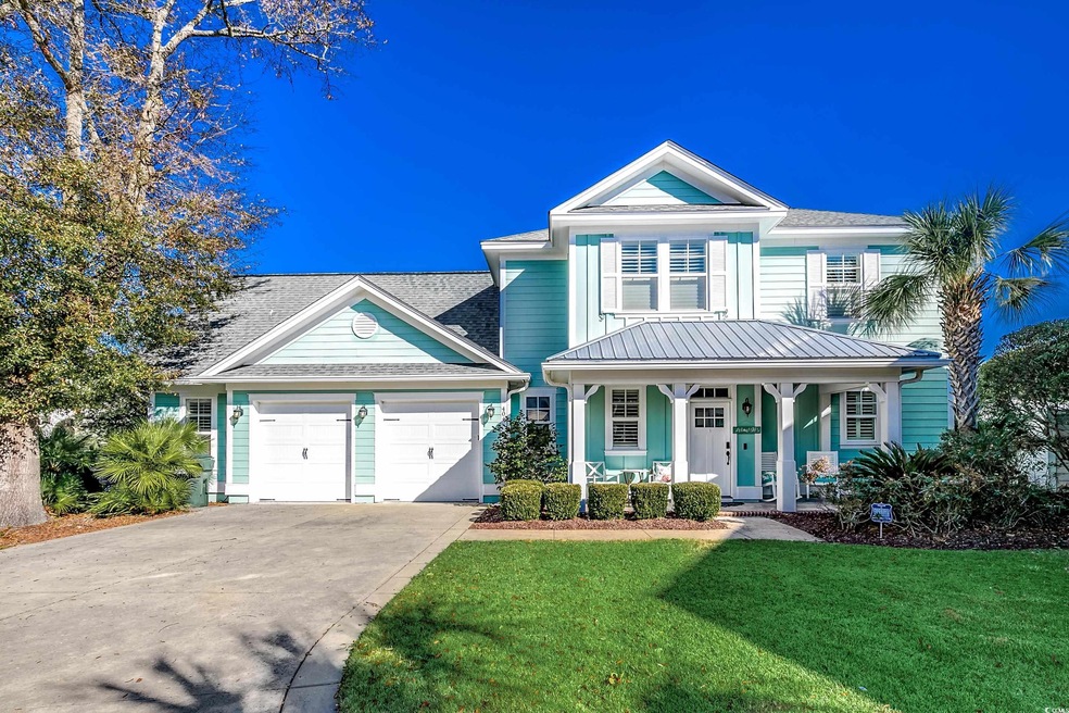 View of front of property featuring a garage, covered porch, and a front lawn