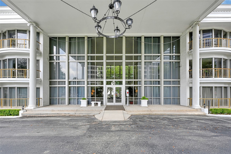 Elegant building entrance framed by modern architecture and lush landscaping, offering a welcoming first impression.