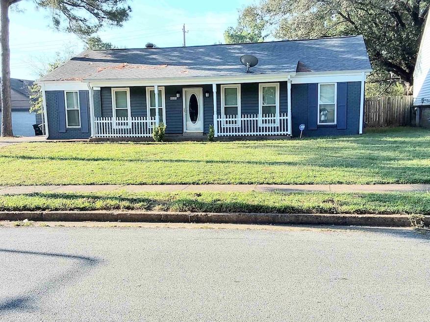Ranch-style house with a front yard, covered porch