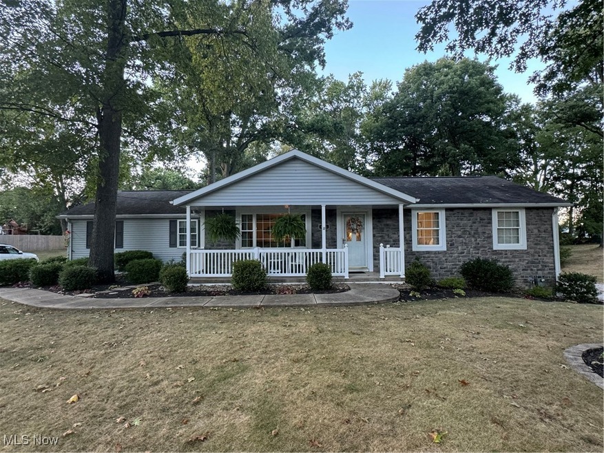 Ranch-style home with covered porch and a front yard