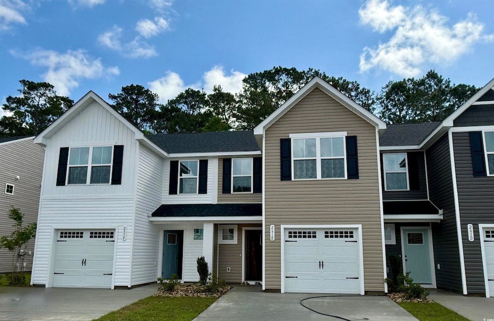 View of front of house with an attached garage, concrete driveway, and roof with shingles