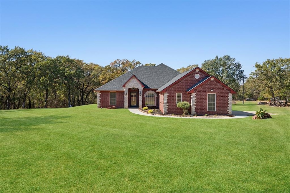 View of front of house with a front lawn, brick siding, and roof with shingles