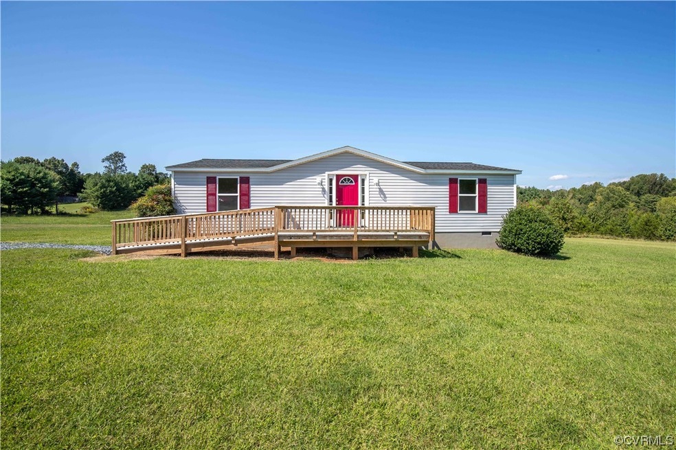 Front of house featuring a lawn and a deck