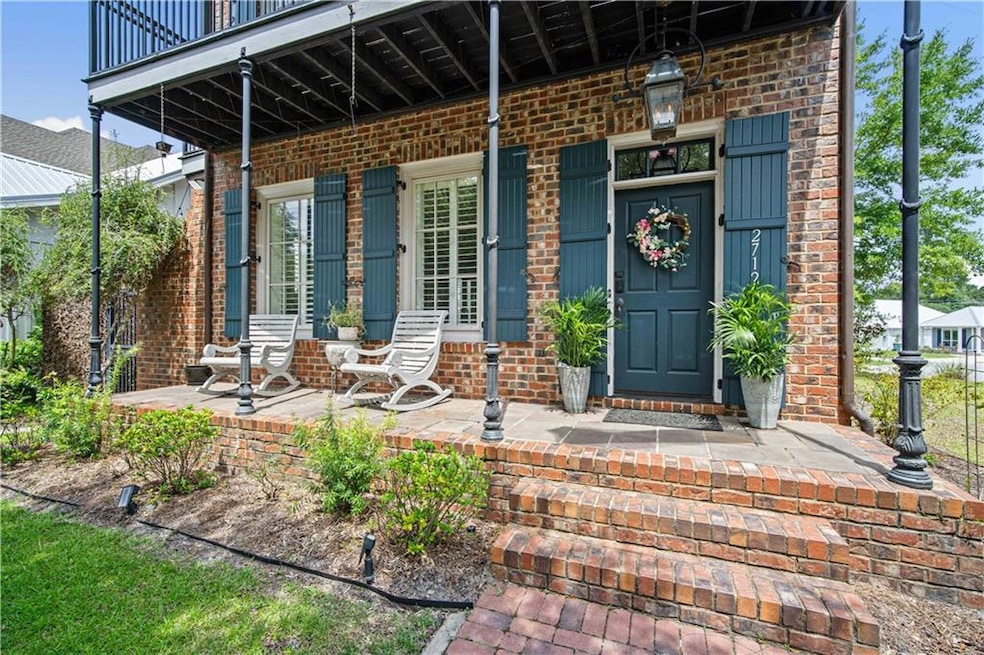 View of exterior entry featuring a porch and brick siding