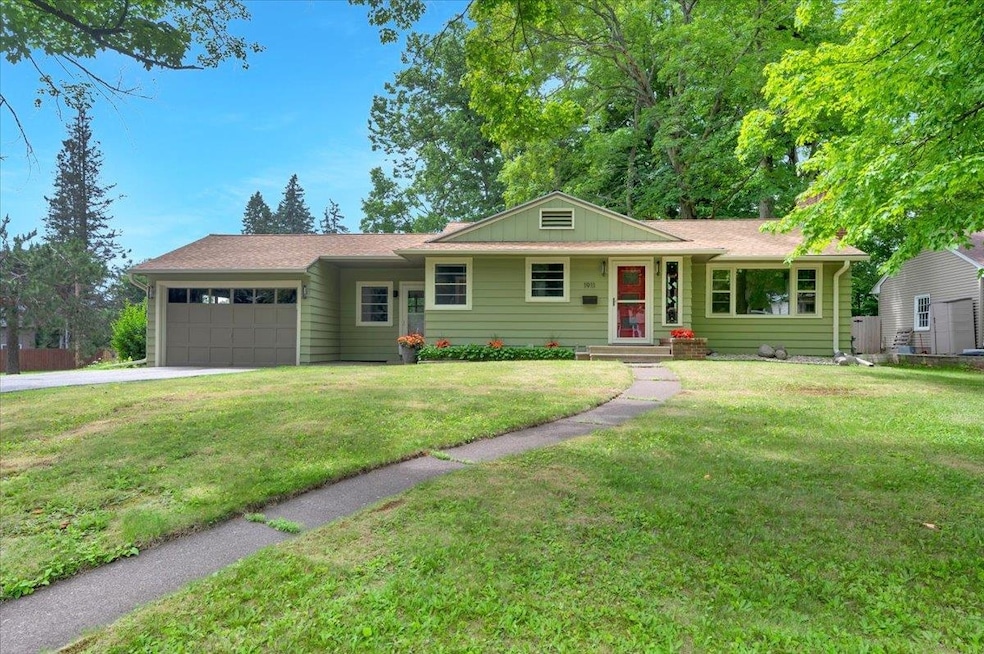 Ranch-style house with a garage, driveway, and a front yard