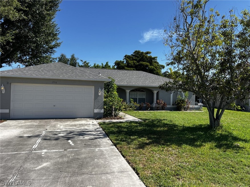 Single story home featuring a garage and a front lawn