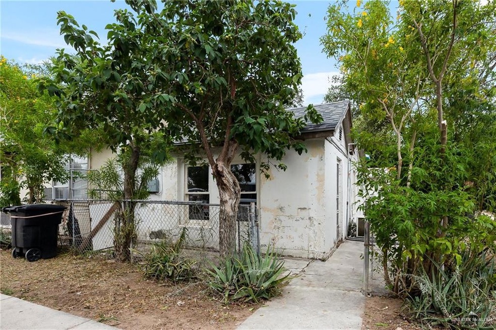 Obstructed view of property with stucco siding, a gate, and roof with shingles