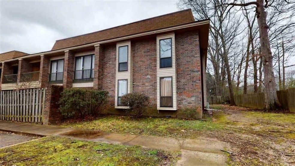 View of front of house with fence and brick siding