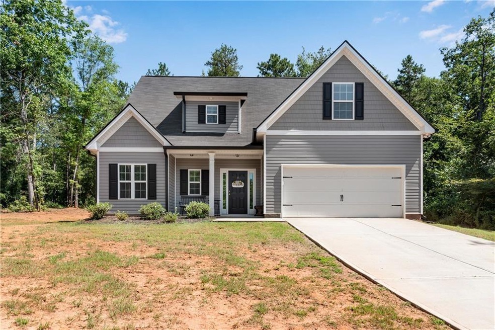 Craftsman-style home with a porch, driveway, a front lawn, and an attached garage