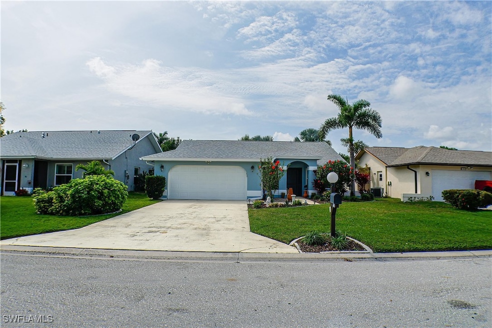 Ranch-style house with a front yard, an attached g