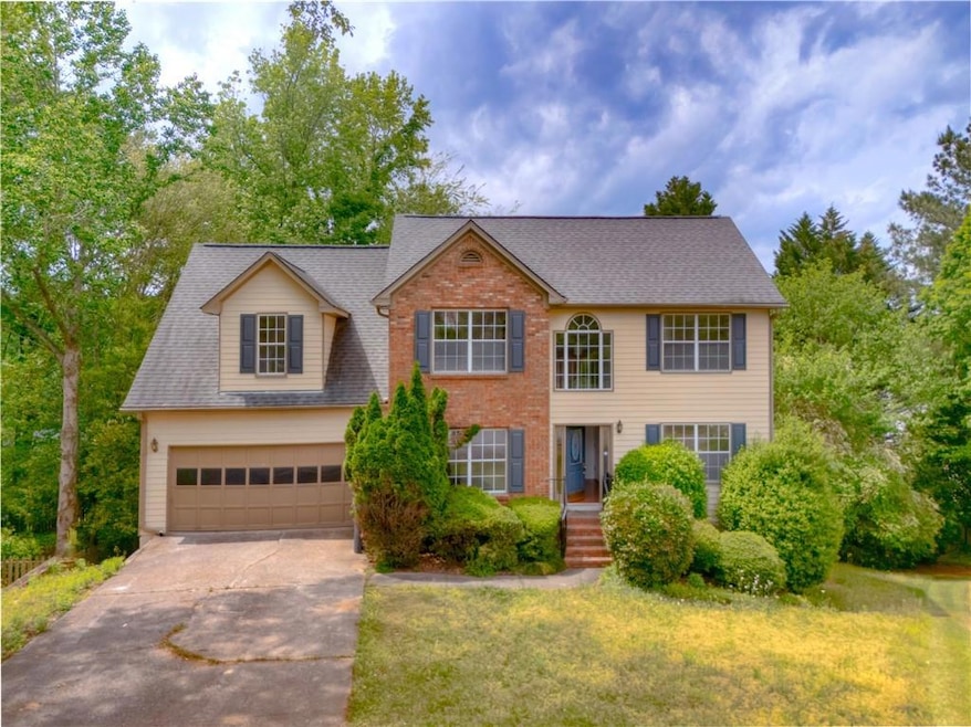 Colonial home with driveway, roof with shingles, a