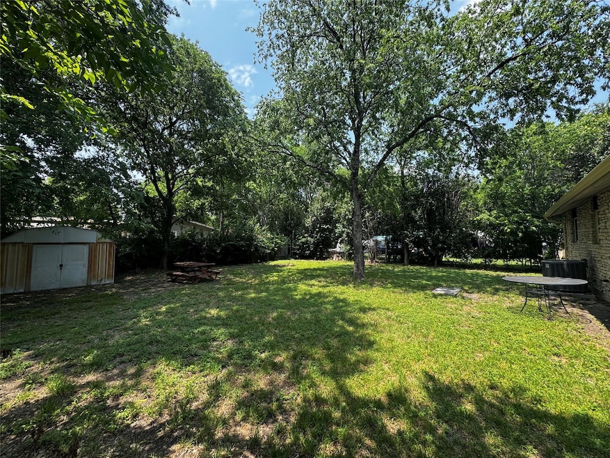 View of grassy yard featuring central air conditi