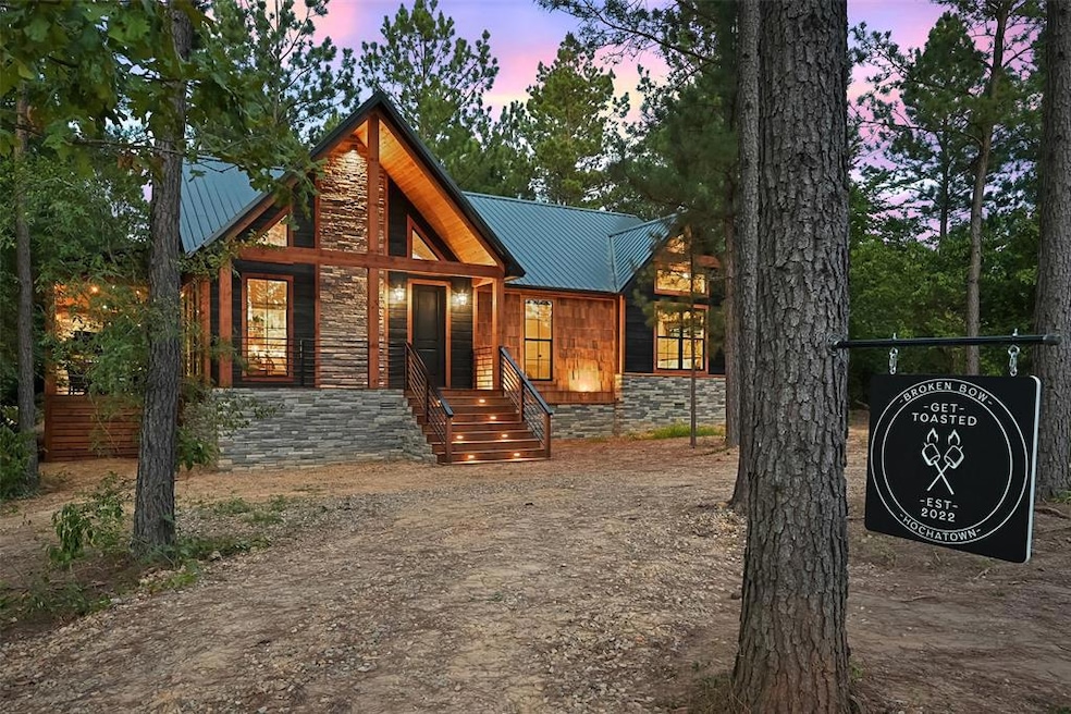 Chalet / cabin with a metal roof and stone siding