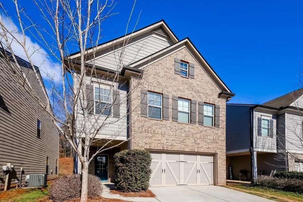 View of front of home featuring a garage and central AC