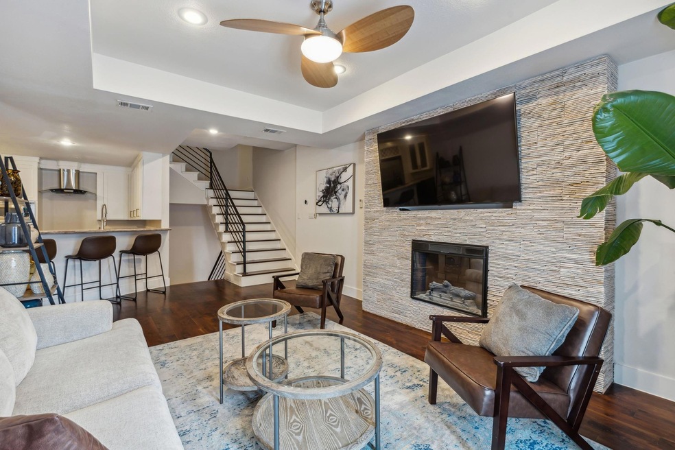 Living room featuring a tray ceiling, ceiling fan,