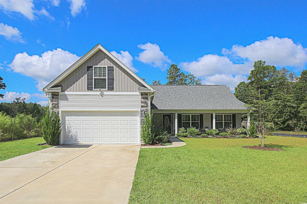 Traditional-style house featuring a front lawn, board and batten siding, driveway, and covered porch