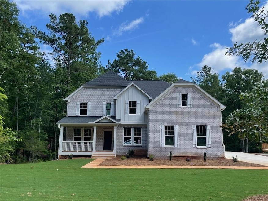 View of front facade with a front yard and covered