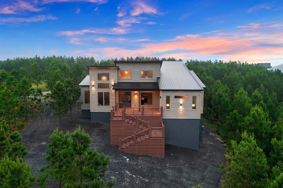 View of front of house with stairs, metal roof, an