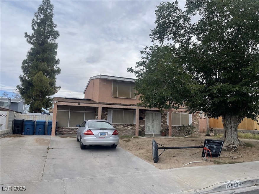 View of front of house with concrete driveway, bri